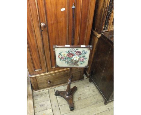 An adjustable rosewood pole firescreen on tripod base with woolwork and beaded screen 