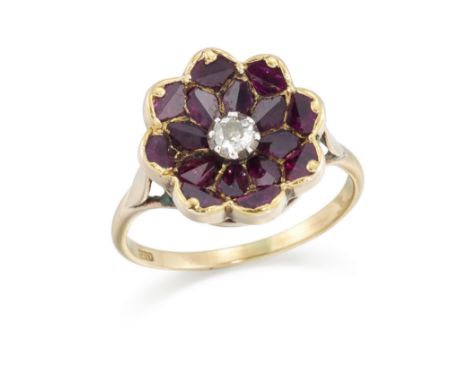 A ruby and diamond ring, designed as a twin faceted calibr&eacute; cut ruby flowerhead closed back cluster with central old b