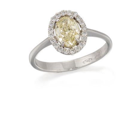 A light yellow diamond cluster ring, an oval brilliant cut light yellow diamond, claw set to halo surround of brilliant cut d