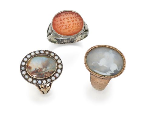 Three 19th century rings, comprising: an early 19th century oval painted miniature depicting cavalrymen in a battle scene, wi