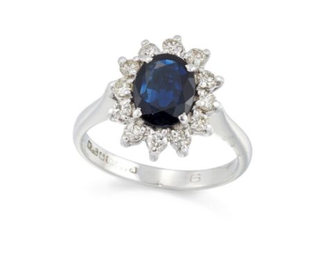 An 18ct white gold sapphire and diamond cluster ring,&nbsp;the oval mixed cut sapphire to brilliant cut diamond surround, wit