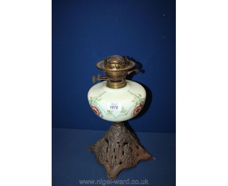 An Oil lamp in Art Nouveau style with milk glass reservoir.