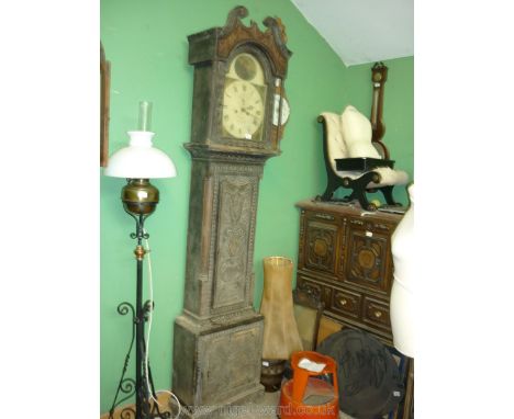 A profusely carved Oak Longcase Clock decorated with stylised foliage, the door with a depiction of an urn containing a styli