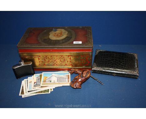 An old large tin and contents including a corkscrew, postcards, pipe, etc.