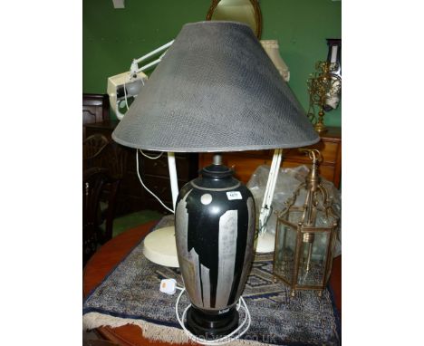 A ceramic table Lamp with stylized New York skyline on black ground detail with skin effect shade, 22" high.