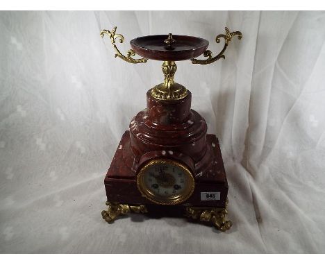 A good Rouge Royale marble cased French mantel clock, the case raised on cast and gilded Rococo supports, white enamel dial w