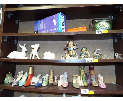 Three shelves containing a quantity of glass ware, ornamental ceramics to include Swaovski crystal animals, Geobel Hummel fig