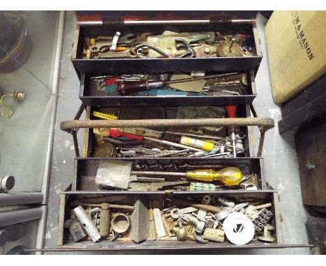 A concertina metal tool box containing a collection of hand tools and a quantity of plumbing tools universal rods and similar