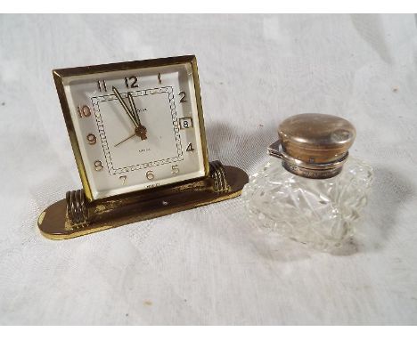 A cut glass jar with hallmarked silver cap and a mechanical 7 jewelled movement alarm clock, the dial scribed Europa (2) 