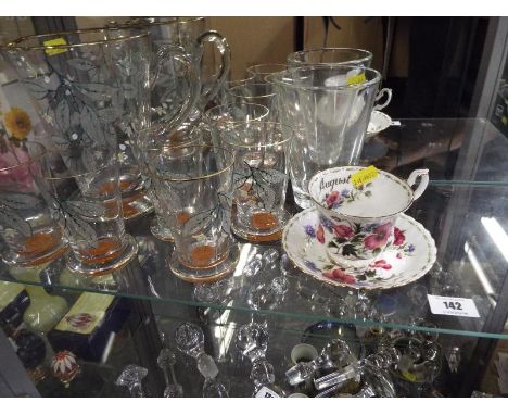 A unusual art glass drinking set to include jug and six drinking glasses decorated with a floral pattern, a Ryal Albert cup a