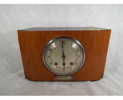 A mahogany cased Garrard Strike mantel clock, Arabic numerals on a silvered dial, presentation plaque to the facia, with key