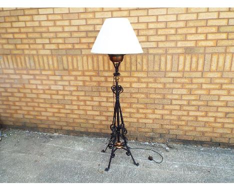 A iron and brass standard lamp with oil reservoir converted to mains electricity with shade 