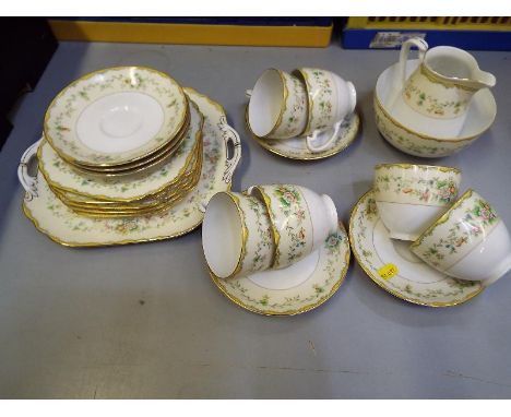 A six place Noritake tea service consisting of cups, saucers, creamer, sugar bowl, sandwich plates, side plates, decorated in