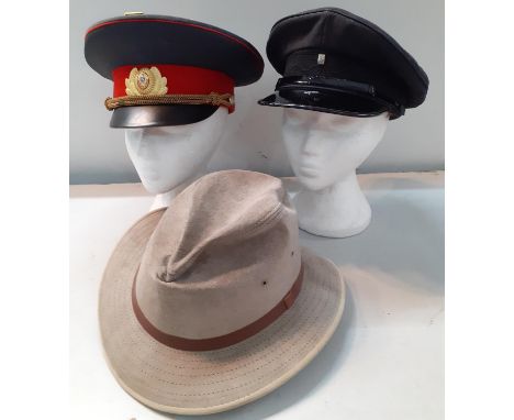 A group of 3 hats to include a Soviet police hat having a quantity of mainly Russian enamelled badges to the crown, a vintage