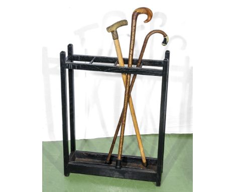 A stick stand and three walking sticks