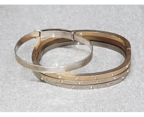 Adjustable sterling belt buckle type bangle together with three white metal unmarked snap bangles inlaid with white stones.