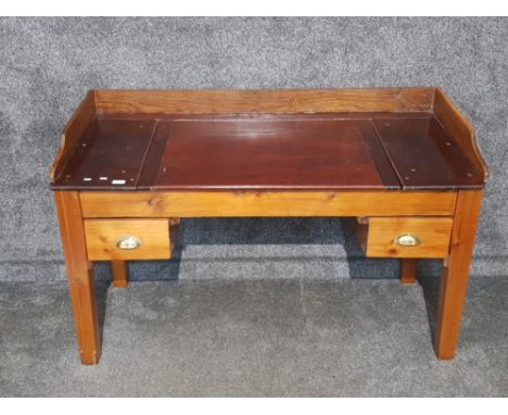 A large pine writing desk fitted with two drawers with brass handles 142 x 90 x 63cm.