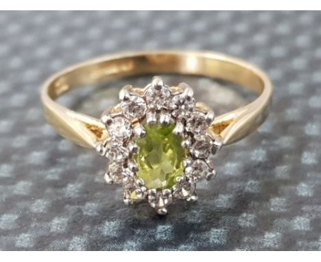 Ladies 9ct yellow gold peridot &amp; cubic zirconia cluster ring comprising of a oval peridot set in the centre surrounded by