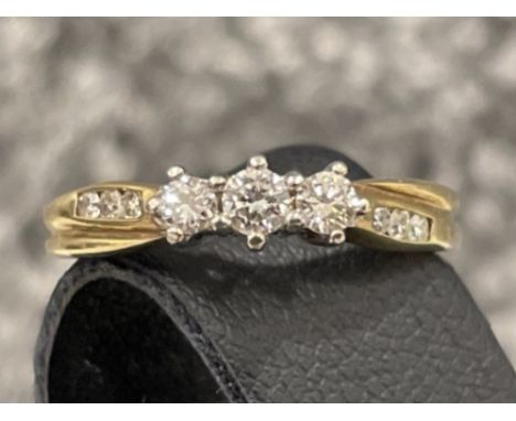 Ladies 9ct gold diamond ring. Comprising of 3 round brilliant cut diamonds and 3 diamonds on each shoulder. Size L 2.2g