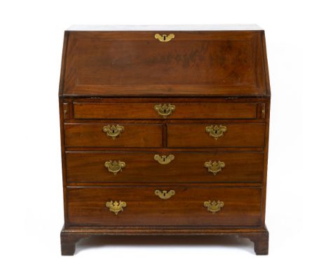 A George III Mahogany Bureau, the fall front opening to reveal short drawers and pigeon holes above five drawers, raised on b