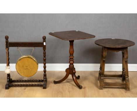 An antique oak circular topped occasional table with turned supports and pegged construction, 35cm diameter x 62cm high toget