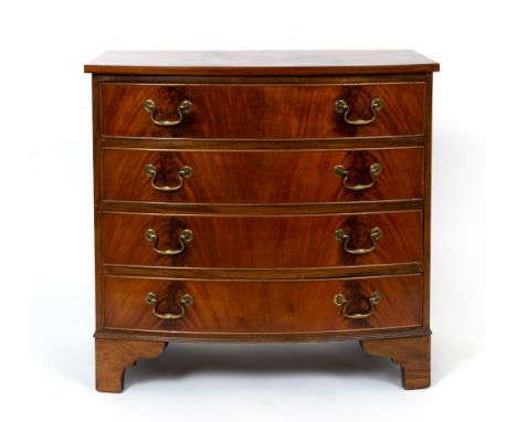 A reproduction Georgian style flame mahogany bow front chest of four long drawers with brass swan neck handles and raised on 