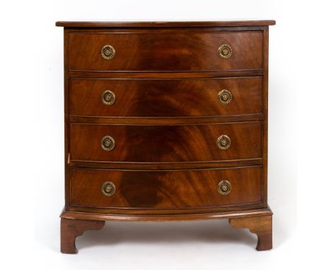 A reproduction Georgian style mahogany bow front chest of four long drawers with brass ring handles and raised on bracket fee
