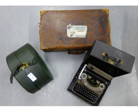 A vintage brown leather suitcase, green leather hat box an a cased typewriter, (3) 