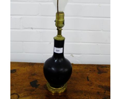 A black glazed ceramic lamp base on an ormolu circular footrim, 24cm high excluding fitting