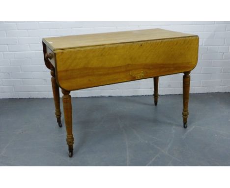 A pine Pembroke table with a single drawer on turned supports and ceramic castors, 76 x 108cm