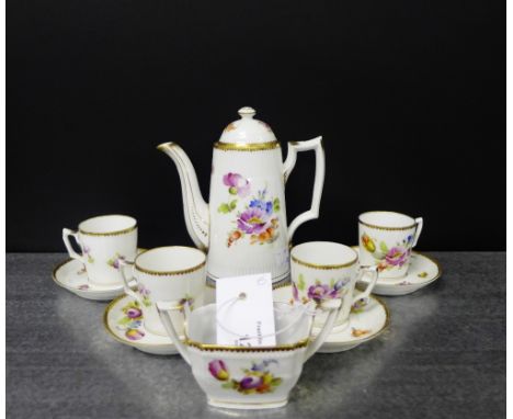 A continental porcelain white glazed coffee set painted with floral sprays within gilded borders, comprising a coffee pot wit