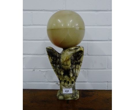 A soapstone table lamp, the base formed as an eagle with its spanned wings holding a domed shade, 35cm high 