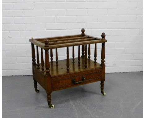 An oak canterbury with a single drawer to the base and turned supports with ceramic castors, 58 x 58cm 