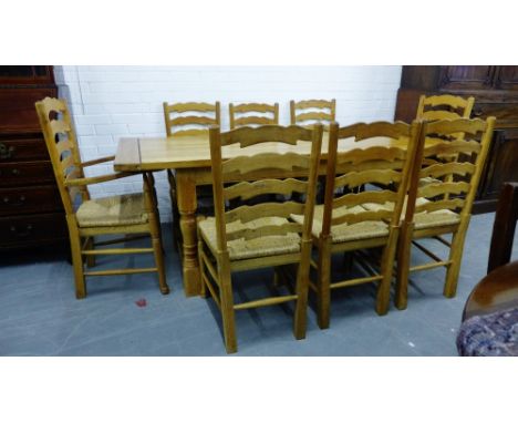 A pine nine piece country pine dining set, comprising a table with rectangular plank top on turned block supports together wi