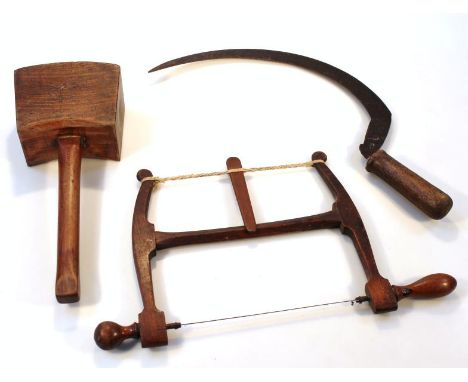 A small quantity of 19thC tools, comprising a mallet by Parlby, 35cm high, a bygone sickle and wooden framed fret saw. (3)