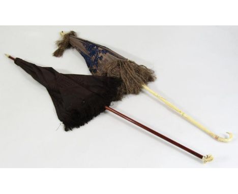 An early 20thC umbrella, with carved ivory handle, 69cm high, and another, with wooden handle, black material centre, ivory k