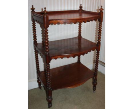 A Victorian mahogany whatnot, of three levels, with bobbin turned supports and serpentine shelves, 60cm wide