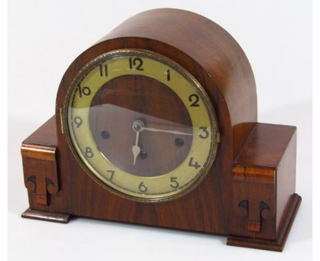 A 1930's Art Deco walnut cased mantel clock, the 17cm dia. dial fitted in a arched case with three winding holes, 23cm high.