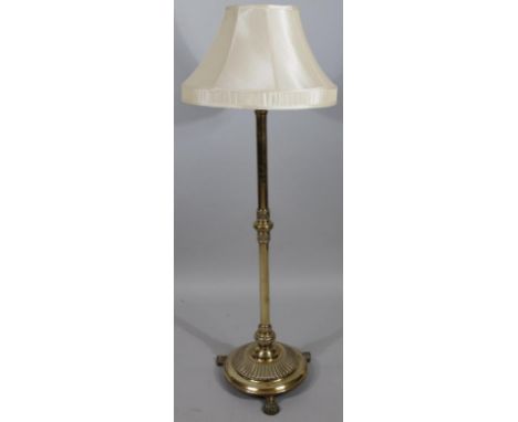 A brass column free standing standard lamp, the cylindrical stem on part gadrooned dome base terminating in hairy paw feet, w