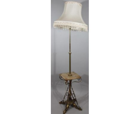 A late 19thC brass standard lamp, with a telescopic column and onyx table centre converted to electricity, with a (later) sha