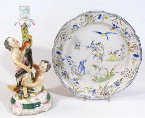 A 19thC Continental porcelain candlestick, formed with a serpent stem, surmounted by a leafy dish holder and set with two che