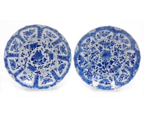 A pair of Chinese blue and white porcelain plates, each with central panel of flower heads surrounded by shaped panels on a c