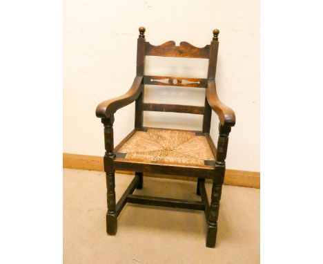 A heavy oak ladder back style carver chair with rush seat 