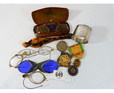 A heavy silver serviette ring engraved with seven badges of the British Army together with a group of spectacles and glasses 