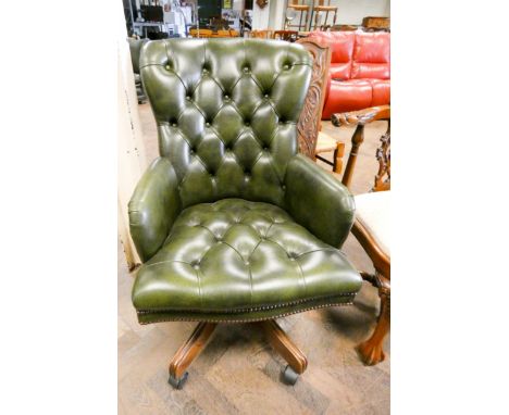 An executives swivel office elbow chair in buttoned green leather   The item is in working order and appears to be in good co
