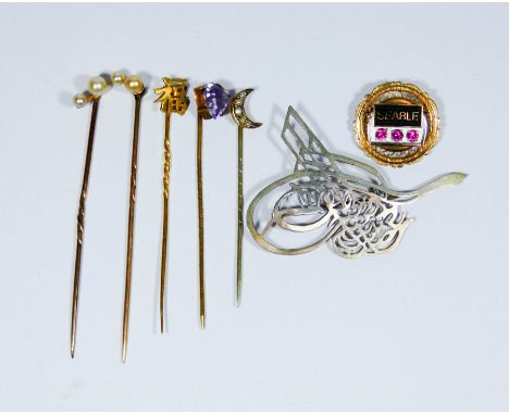 A collection of five stick pins and two brooches