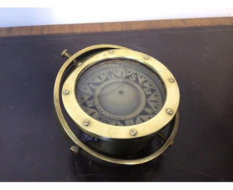 A late 19thc/early 20thc brass cased liquid filled ship's compass, with a gimble mounting (d.16cm)
