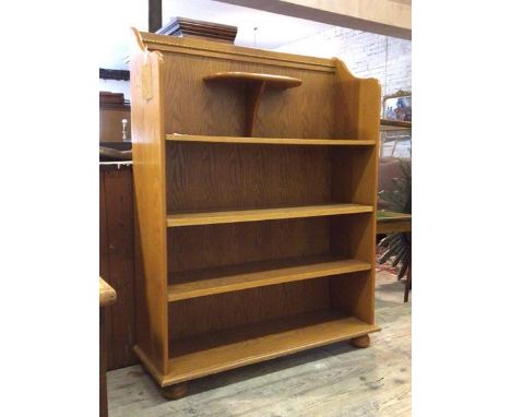 A modern oak open bookcase, the raised back with egg and dart moulding over open shelf and two adjustable shelves, raised on 