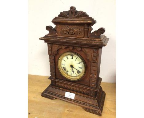 A 1920s mantel clock, the oak case with architectural carving, the dial with roman numerals (45cm x 33cm x 15cm)