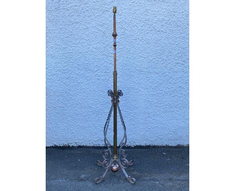 An Edwardian cast brass and wrought iron telescopic floor lamp, the ratcheted rise and fall stem over scroll iron decoration,